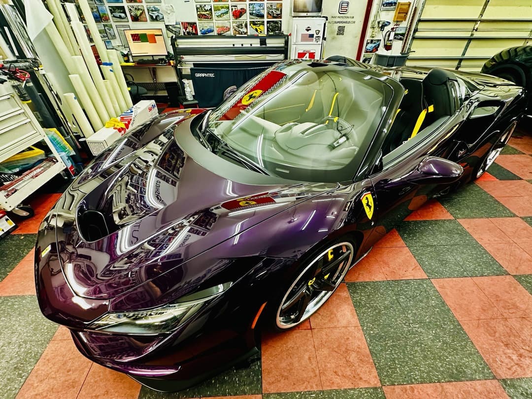 Purple color-wrapped Ferrari on the checker floor